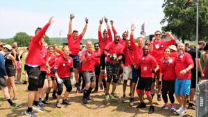 A group of people in red shirts and black shorts.