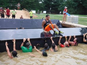 A man jumping over another person in the water.